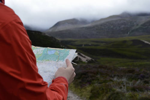 a person with the maountains in front holding a map.